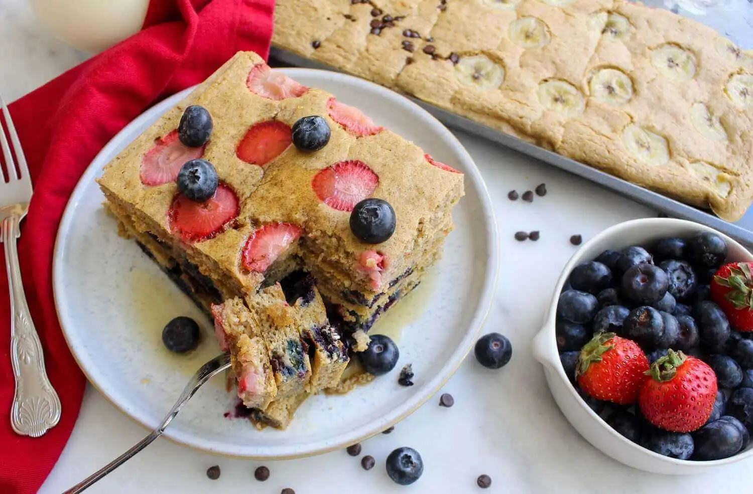 Pancakes With Strawberries And Blueberries On A Plate And A Sheet Pan At The Background